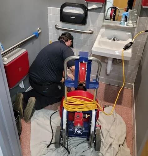 Technician unclogging bathroom toilet in Elk Grove