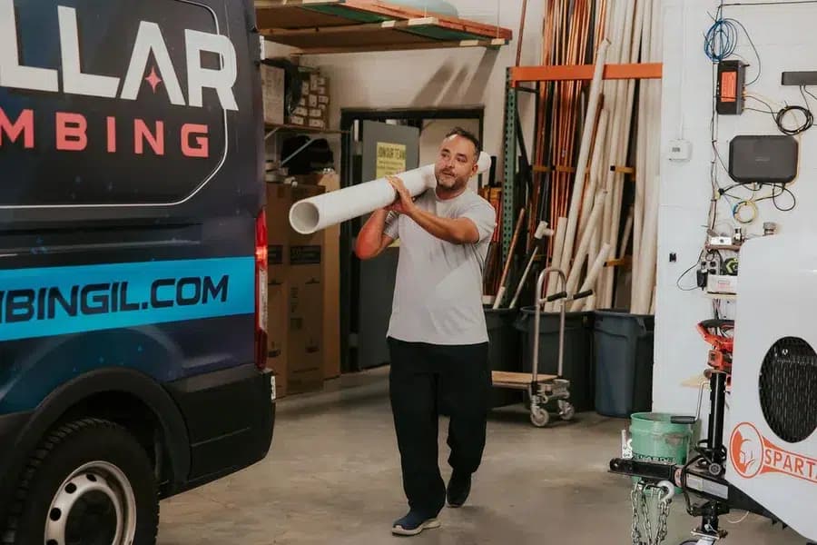 Stelar Plumber carrying PVC pipe after performing drain cleaning in Arlington Heights, IL