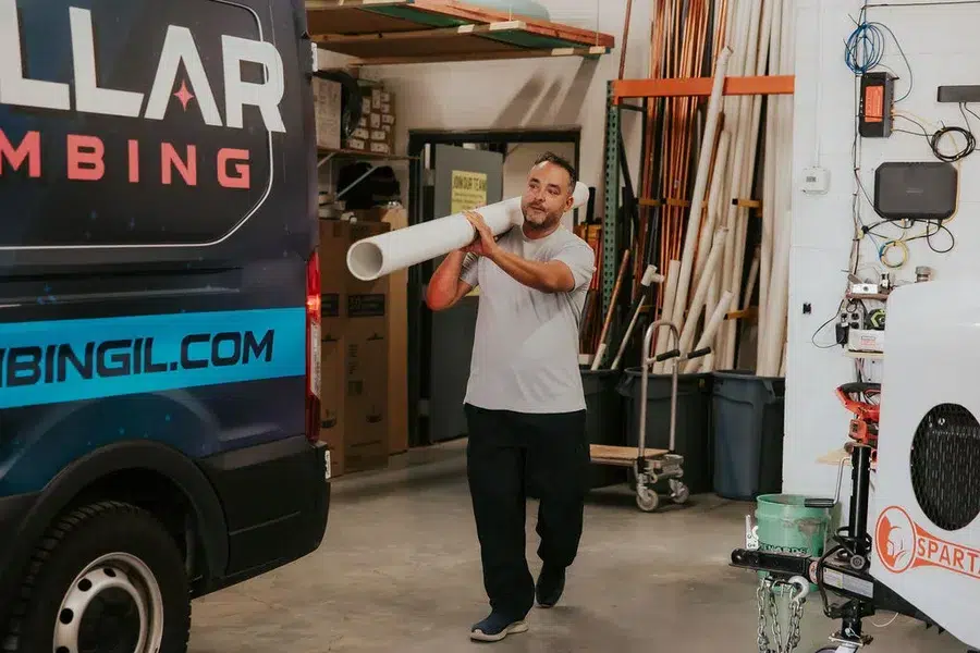 Stelar Plumber carrying PVC pipe after performing drain cleaning in Arlington Heights, IL