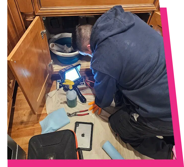 Stellar Plumbing technician using a camera inspection tool to diagnose an under-sink leak in Elk Grove Village area home